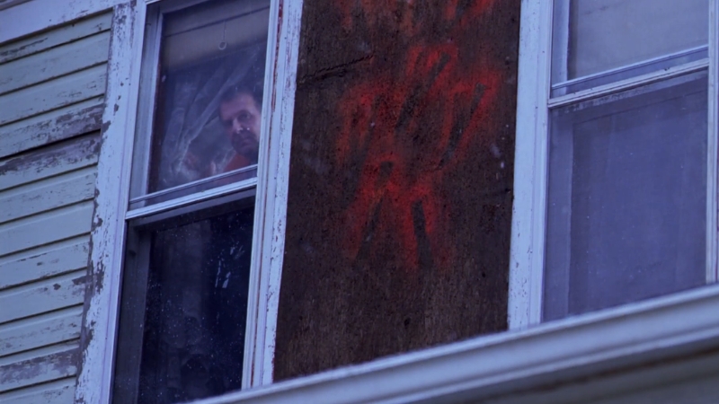 Muškarac posmatra kroz prozor stare kuće u napetoj sceni iz filma po istinitom događaju